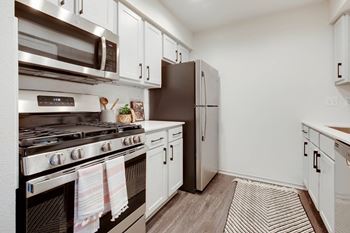 A kitchen with stainless steel appliances and white cabinets